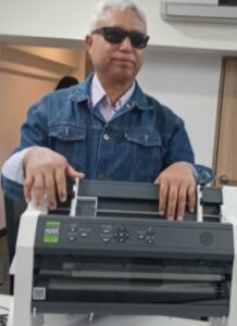 Schulleiter U Tin Moe präsentiert stolz den neuen Brailledrucker