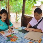 Ein junger blinder Mann aus Myanmar schreibt Blindenschrift nach Diktat