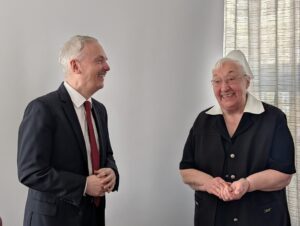 Schwester Lilly Singer und A. Chrzanowski nebeneinander stehend im Gespräch und beide lachend