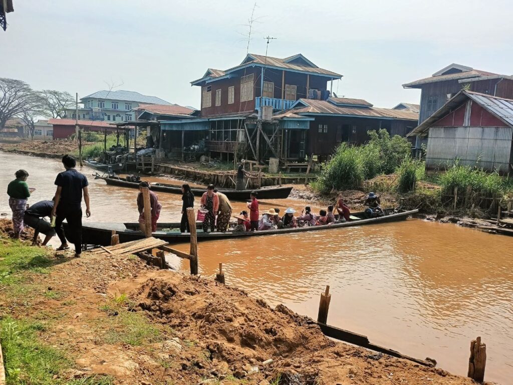 Unterwegs mit einem langen Holzboot am Inle-See in Myanmar